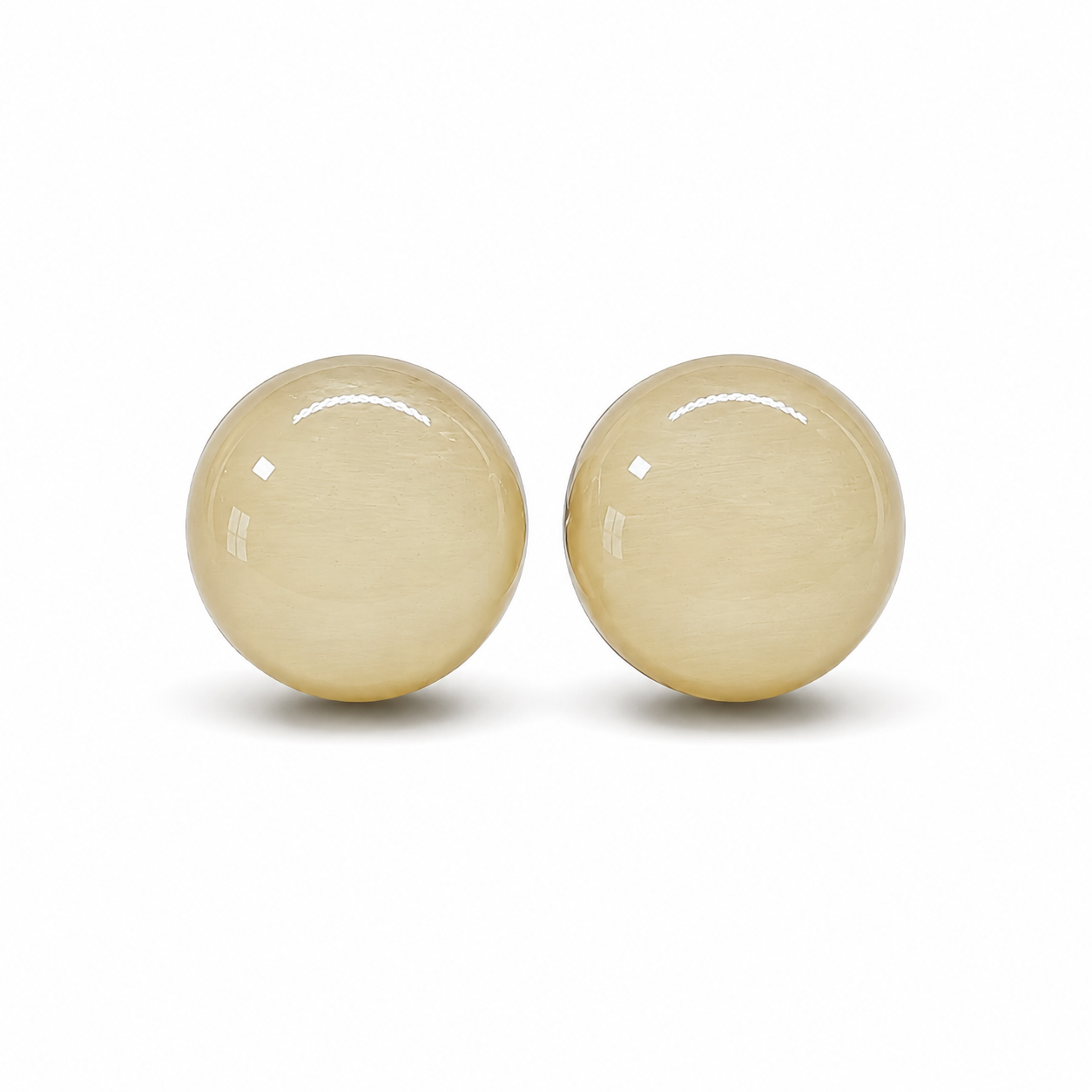 Pair of beige round earrings on a white background