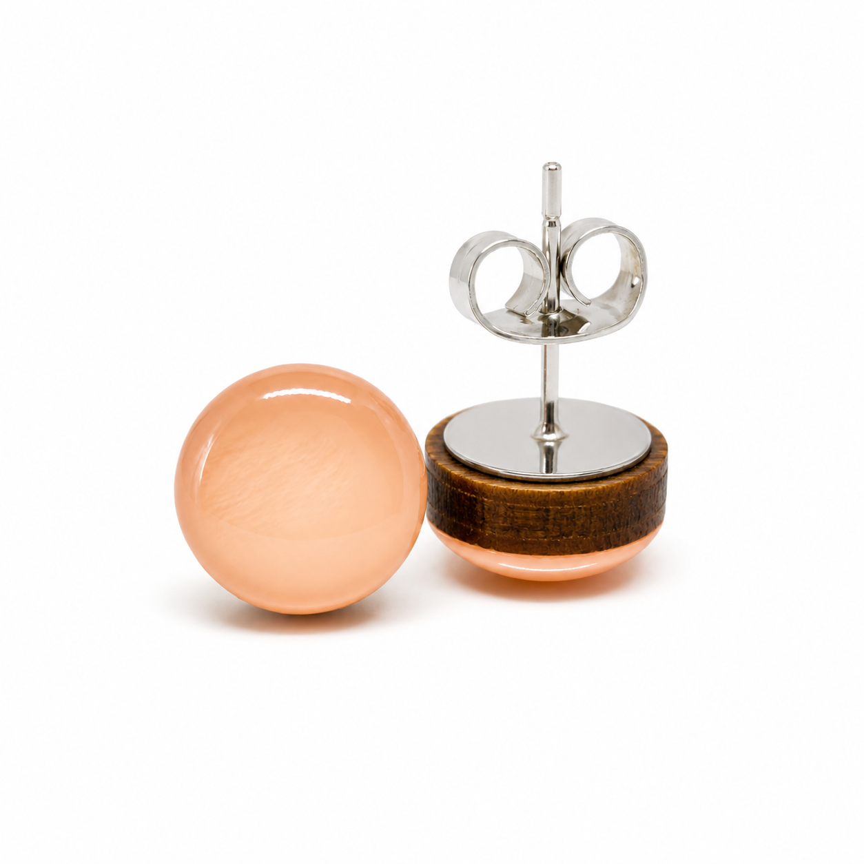 Pair of earrings with peach-colored spherical stones on a white background
