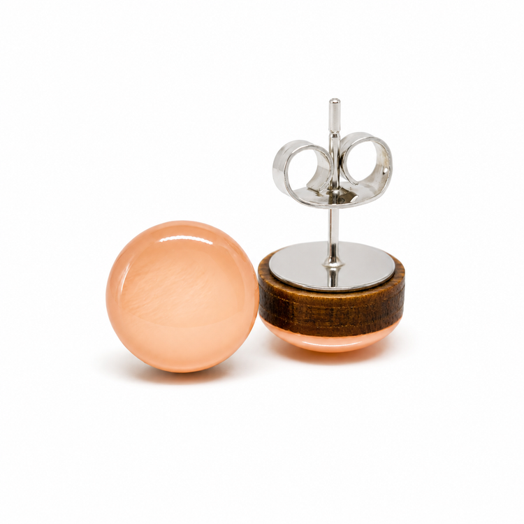 Pair of earrings with peach-colored spherical stones on a white background