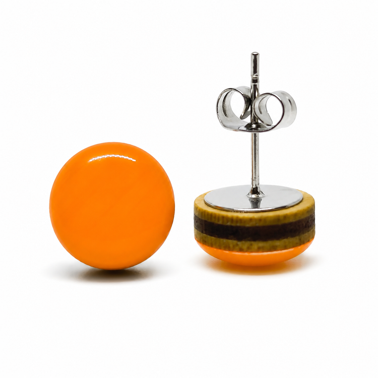 Orange round earring and its backing on a white background