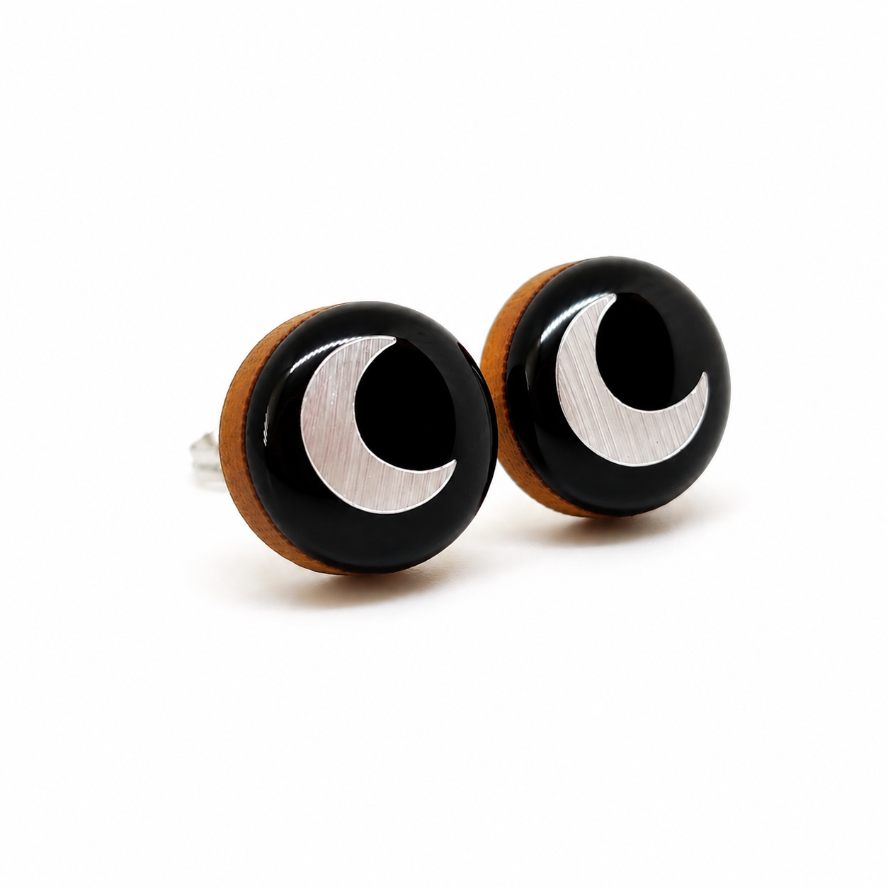 Pair of earrings with black and white crescent moon design on a white background