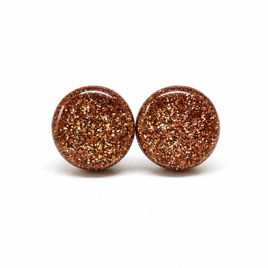 Pair of round rose gold glittery earrings on a white background