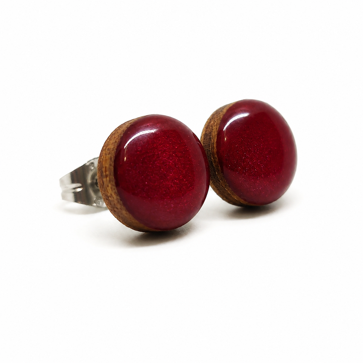 Pair of red round earrings with wooden accents on a white background