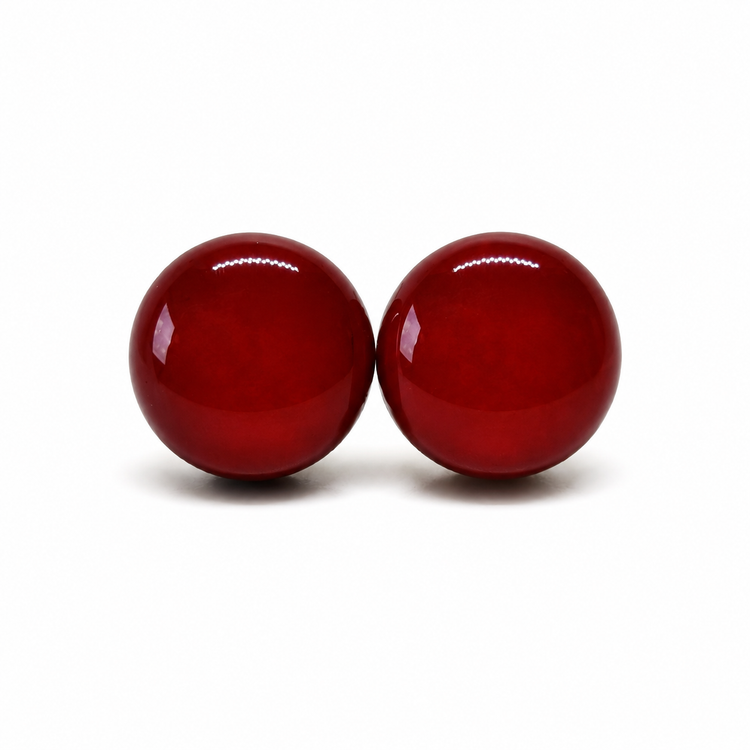 Two red burgundy spherical objects on a white background